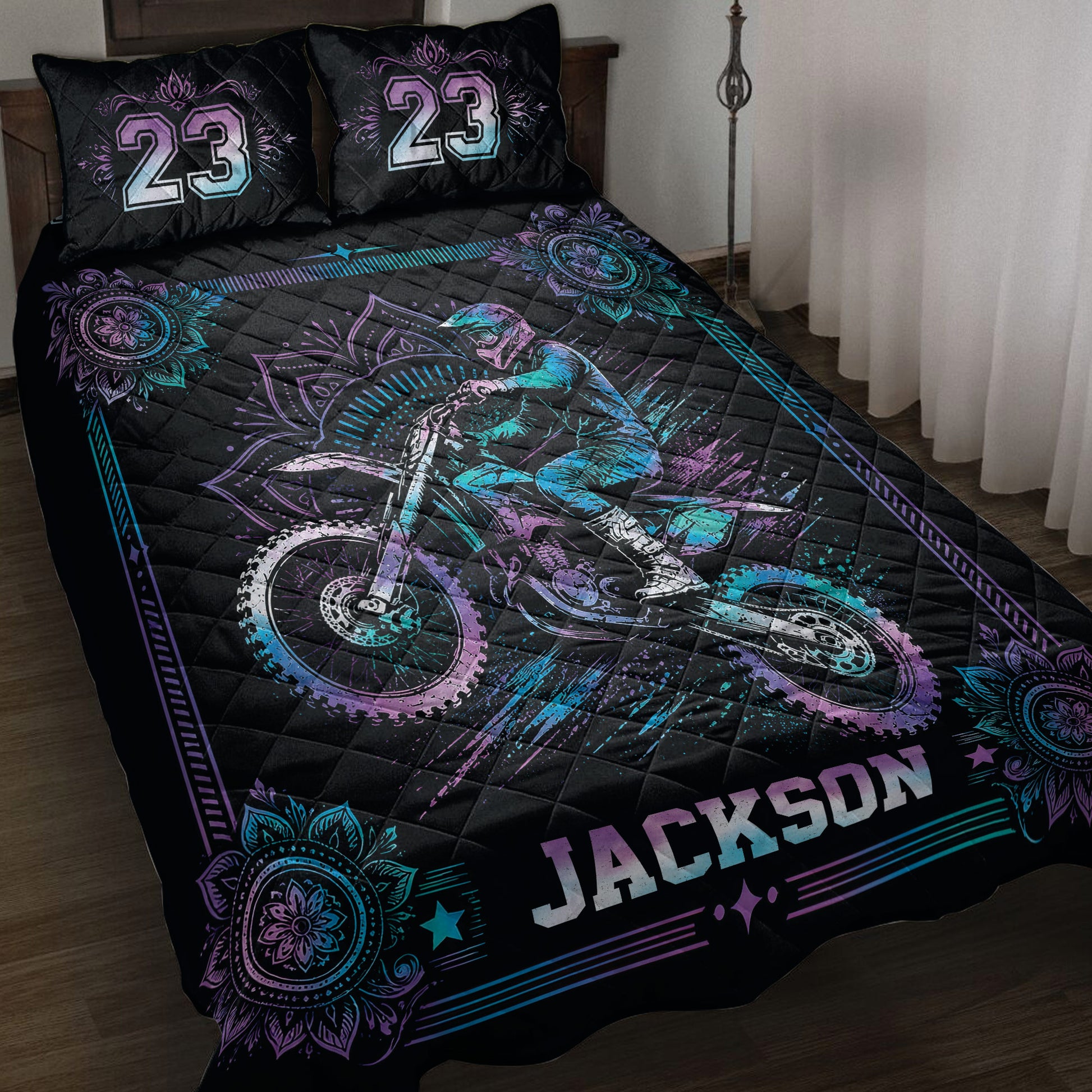 Black motocross quilt blanket on a bed with neon purple and blue dirt bike artwork