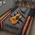 Close bedroom view of a guitar quilt blanket featuring a large acoustic guitar and distressed patriotic colors