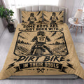 Motocross quilt bedding arranged in a bright bedroom with rugged dirt bike racing artwork in tan and black