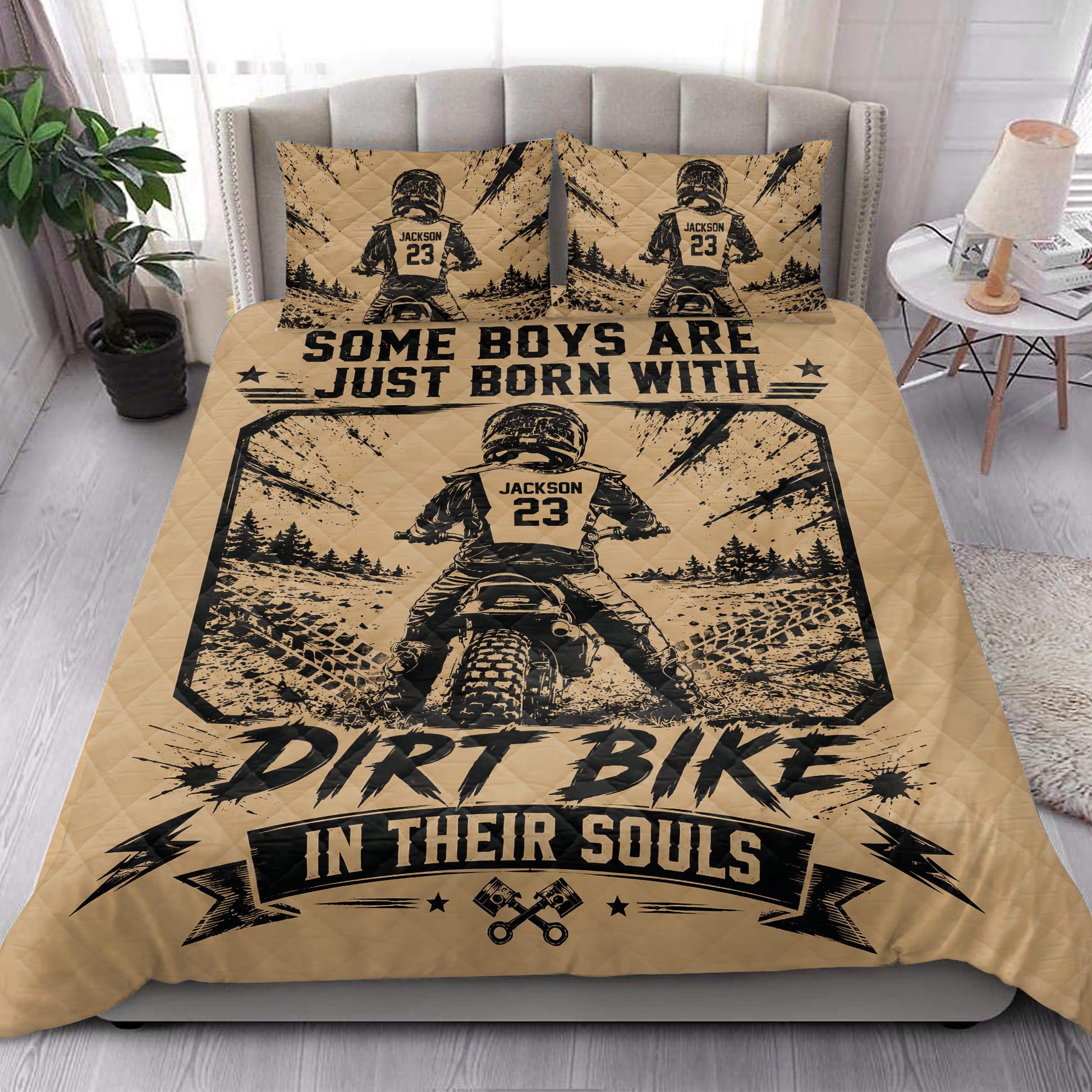 Motocross quilt bedding arranged in a bright bedroom with rugged dirt bike racing artwork in tan and black