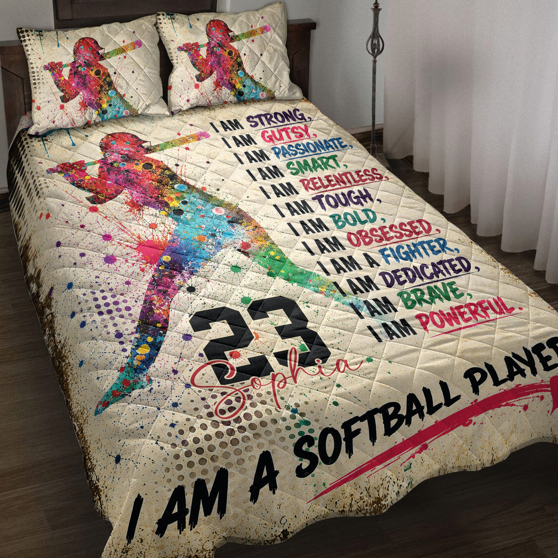 Colorful softball player quilt blanket displayed on a bed with motivational sports artwork