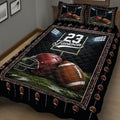 Close view of black football quilt bedding with helmet, football, field, and stadium border design