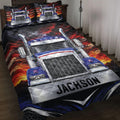 Trucker quilt blanket displayed on a bed with a bold blue semi-truck and fiery red mountain artwork