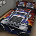 Angled bedroom view of a trucker quilt with detailed big rig artwork and dark red, blue, and black colors