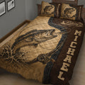 Close bedroom view of a fishing quilt blanket featuring a detailed bass, fishing rod, reel, and rustic artwork