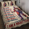 Hockey quilt blanket displayed on a bed with ice hockey player artwork and bold red and navy motivational design