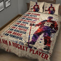 Close bedroom view of a hockey quilt blanket featuring an ice hockey player, stick, puck, and dynamic splatter art