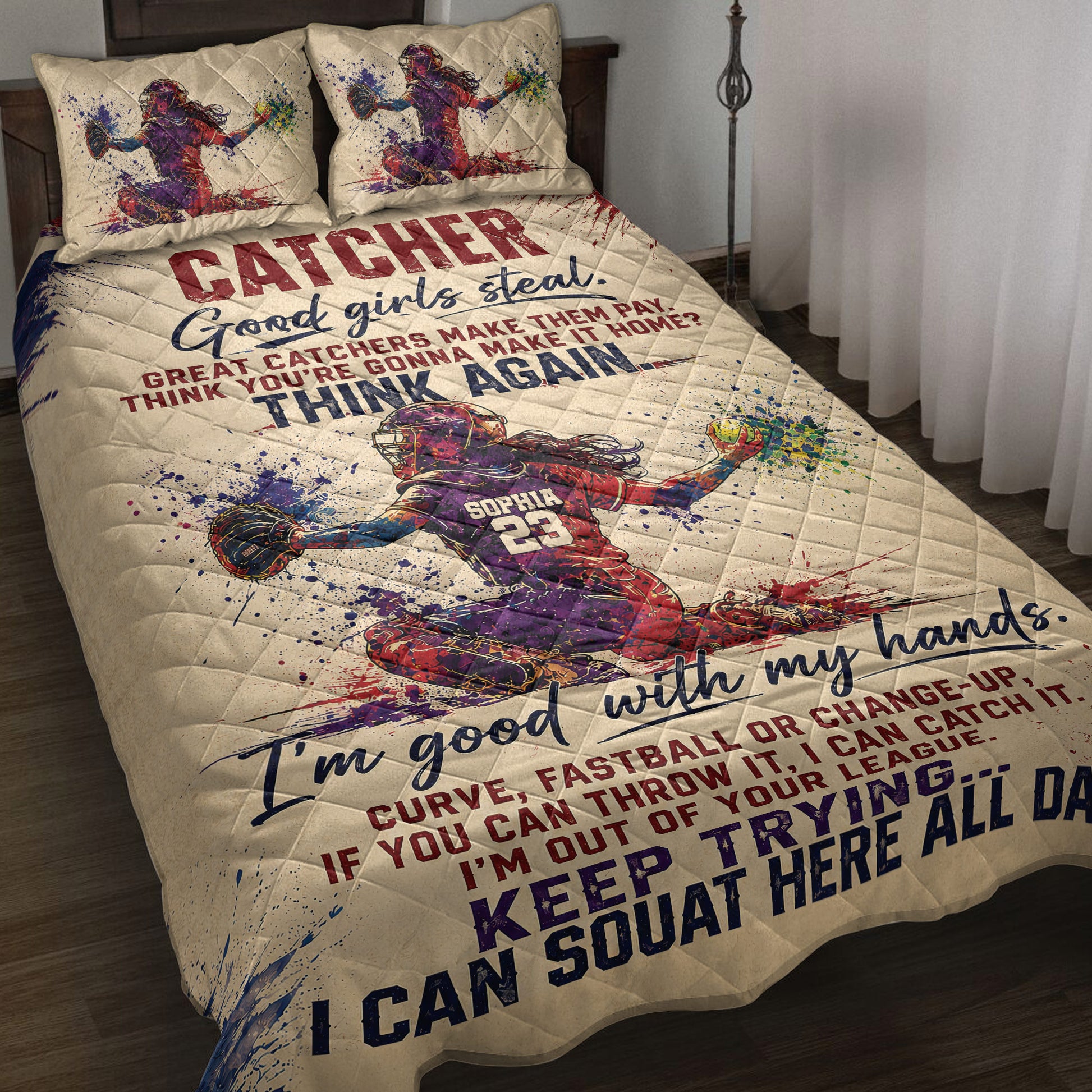 Softball catcher quilt blanket displayed on a bed with colorful splatter artwork and bold sports typography