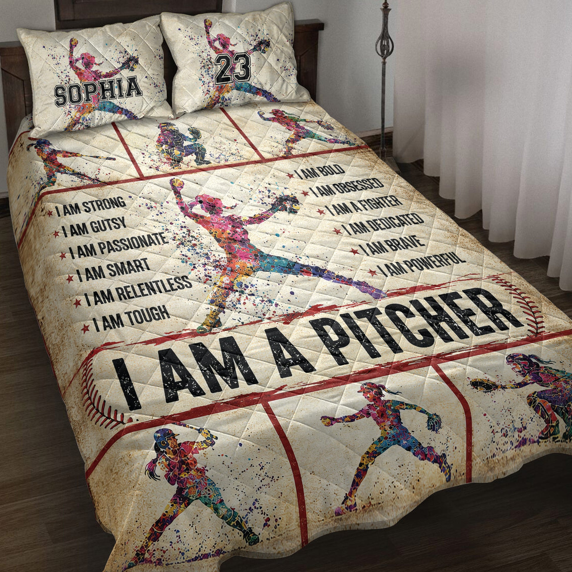 Softball quilt blanket displayed on a bed with colorful female player artwork, baseball diamond accents, and motivational sports graphics