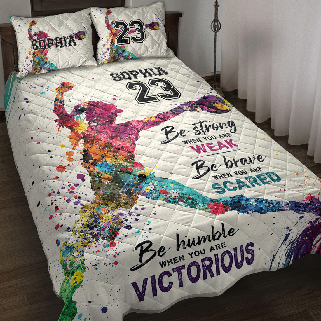 Colorful softball player quilt blanket displayed on a bed with bold sports artwork and motivational design