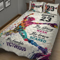 Angled bedroom view of a vibrant softball quilt blanket with player artwork and motivational phrases