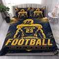 Football-themed quilt bedding styled in a bright bedroom with navy and gold sports artwork