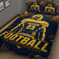 Close view of a navy football quilt blanket with bold gold player and field graphics