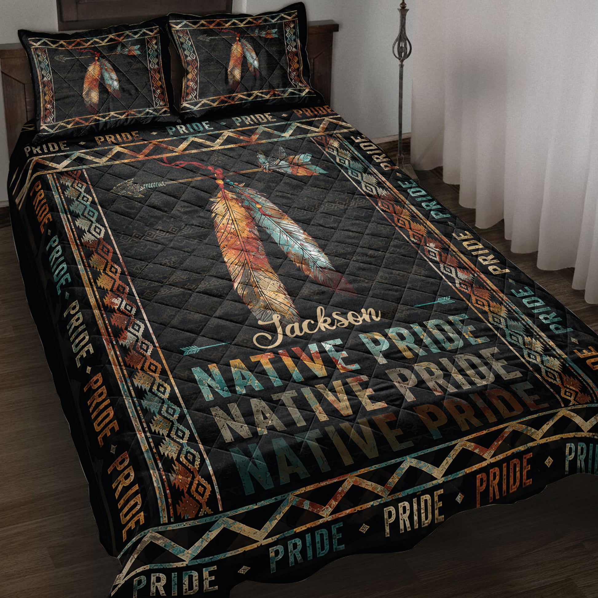 Native Pride quilt blanket displayed on a bed with colorful feathers, arrows, geometric borders, and dark artwork