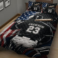 Close bedroom view of a baseball quilt blanket with batter, bat, glove, and bold sports artwork
