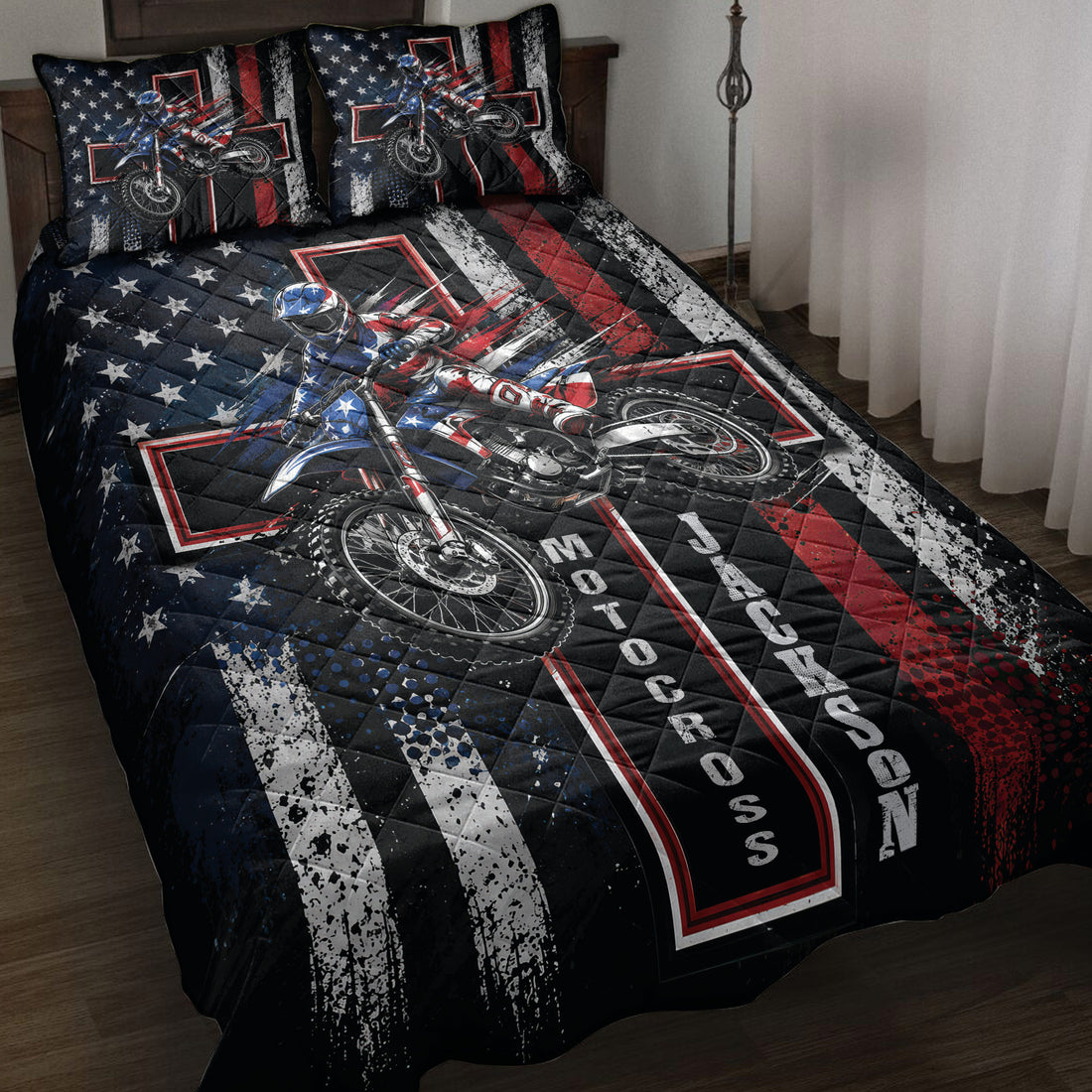 Motocross quilt blanket displayed on a bed with dirt bike rider artwork in black, red, white, and blue