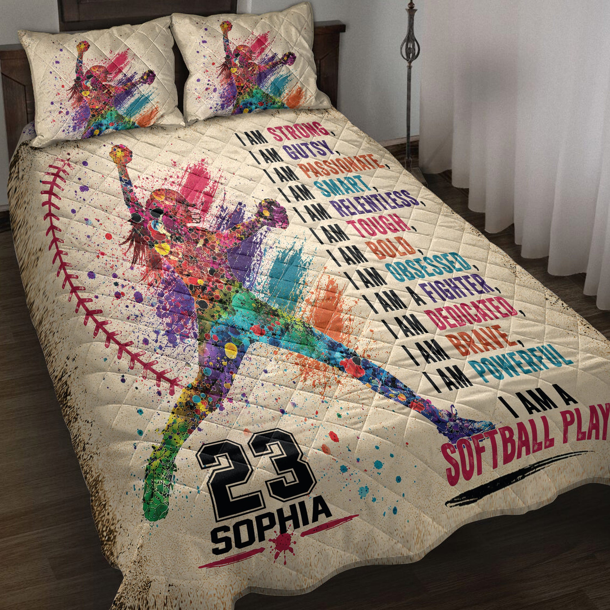 Colorful softball player artwork and motivational sports design displayed on a quilt blanket in a bedroom