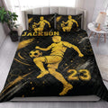 Soccer quilt blanket styled in a bright bedroom with bold black and gold player artwork