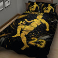 Black and gold soccer quilt spread across a bed with dynamic player and soccer ball artwork