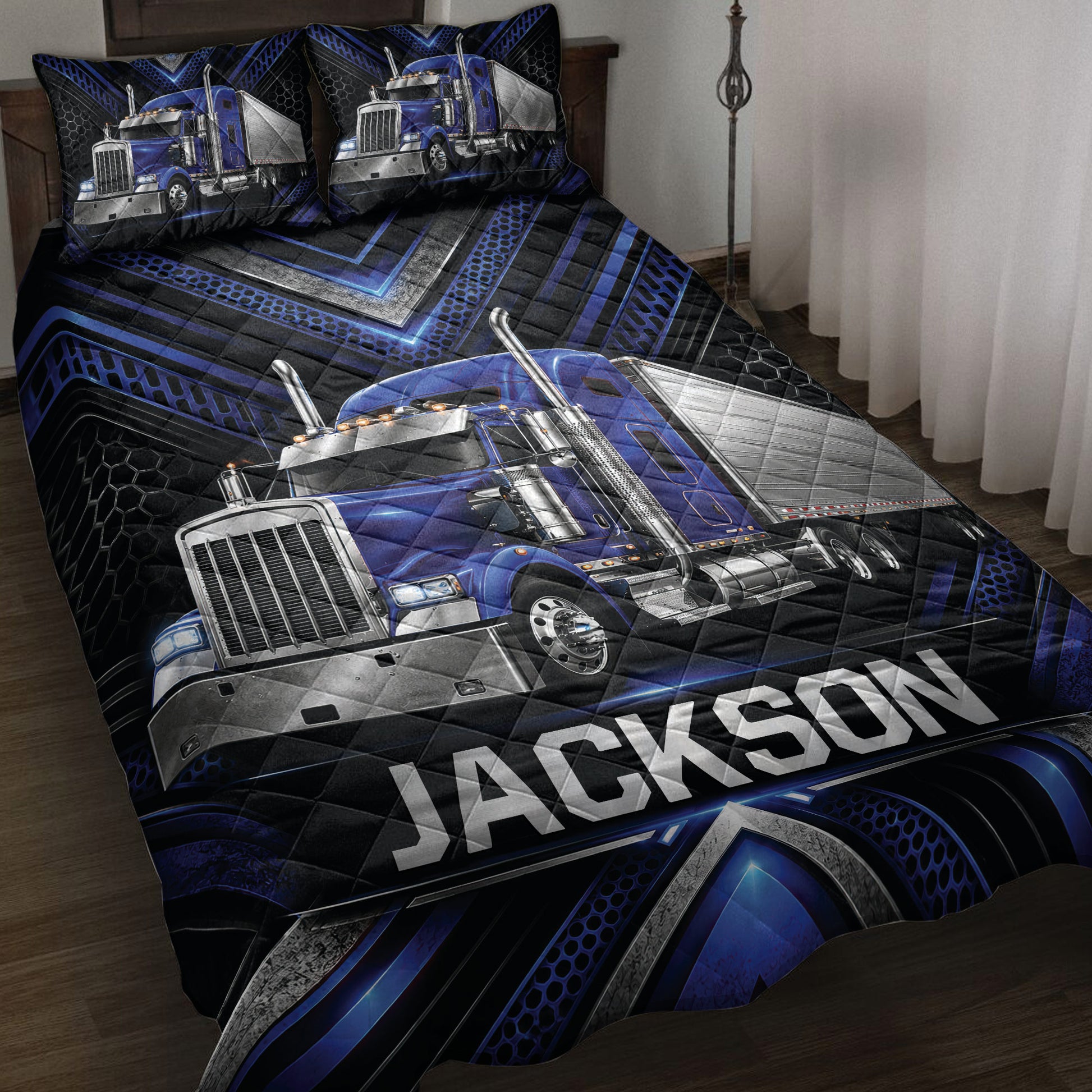 Blue semi-truck quilt blanket displayed on a bed with black and blue geometric detailing