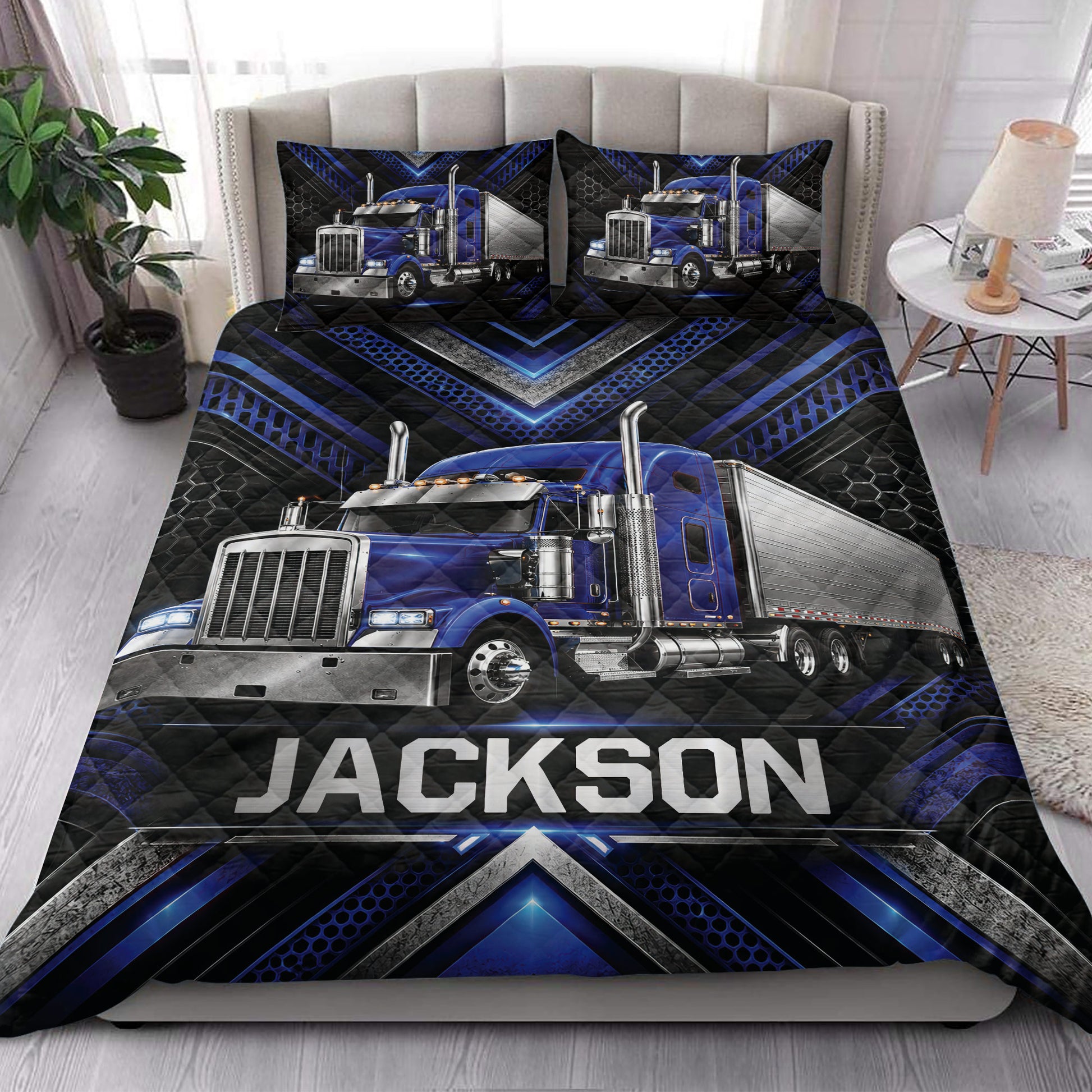 Trucker quilt blanket styled on a bedroom bed with blue semi-truck artwork and geometric borders