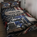 Trucker quilt blanket on a bed with blue semi-trucks, stars, and distressed red, white, and blue artwork