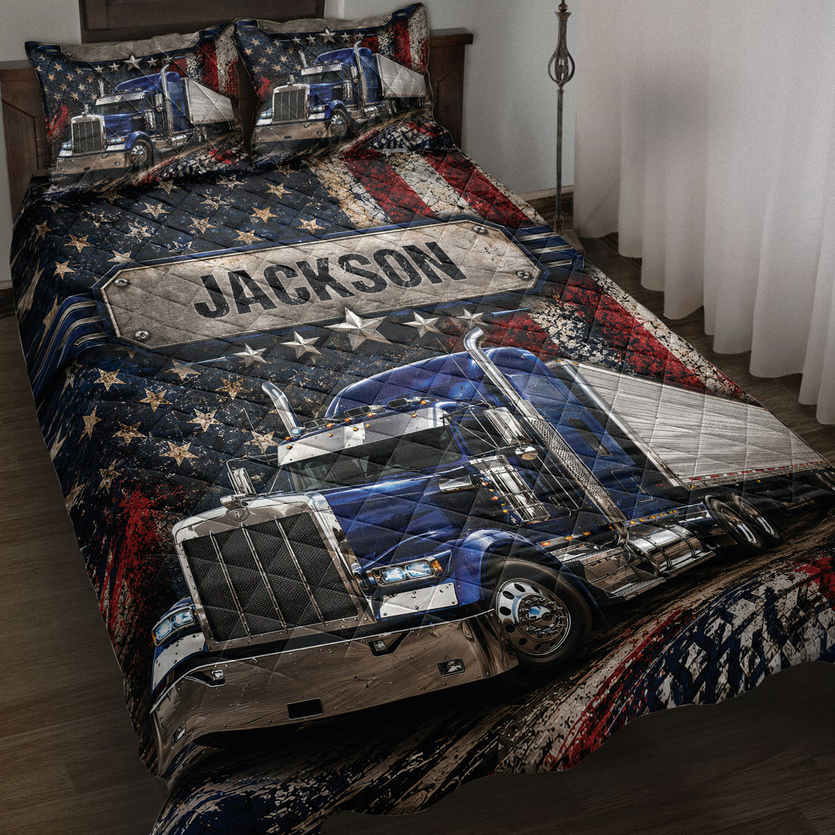 Trucker quilt blanket on a bed with blue semi-trucks, stars, and distressed red, white, and blue artwork