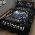 Close view of a trucker quilt blanket featuring a detailed blue semi-truck against a stormy background
