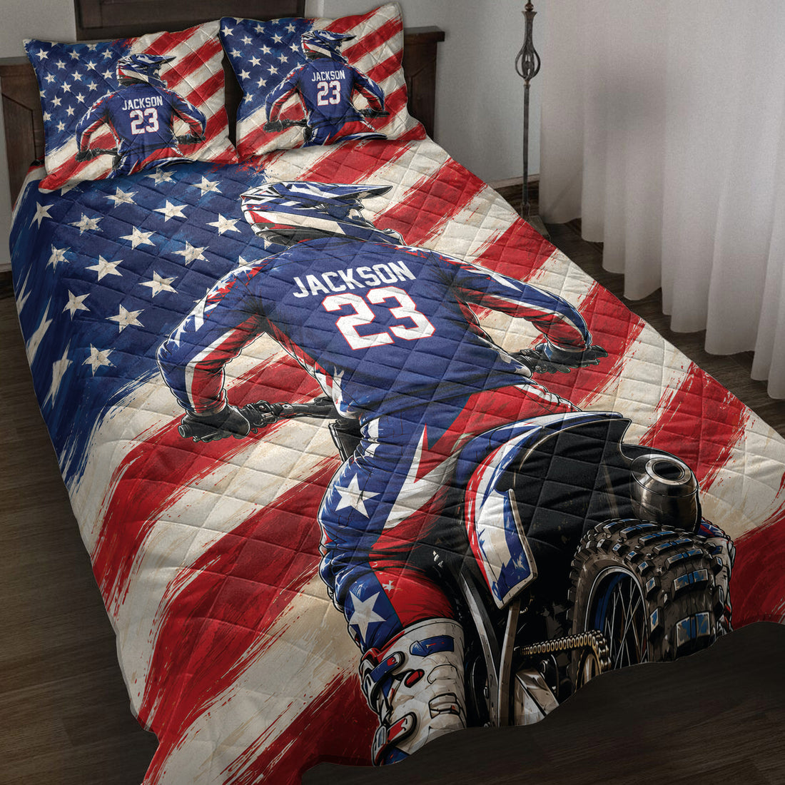 Motocross quilt blanket displayed on a bed with a dirt bike rider and patriotic red, white, and blue artwork