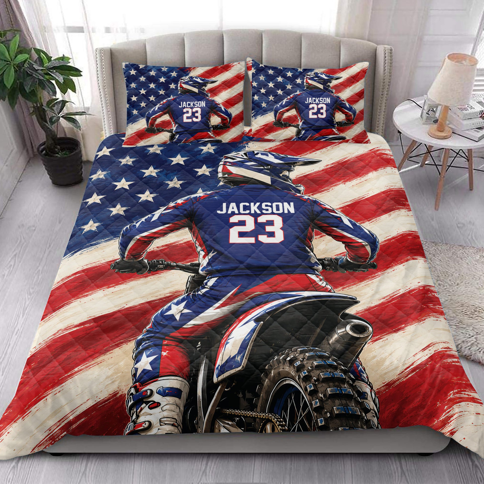 Motocross quilt bedding styled in a bright bedroom with a dirt bike rider and patriotic racing artwork