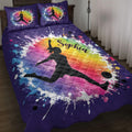 Purple soccer quilt blanket on a bed with female player silhouettes, soccer balls, and colorful rainbow paint splashes