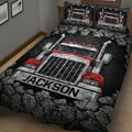Close view of a black and red semi truck quilt blanket arranged across a bed in a trucker-themed bedroom