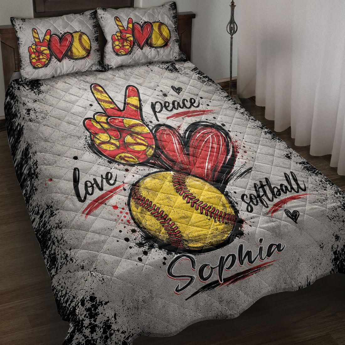 Softball quilt blanket displayed on a bed with red and yellow softball artwork, hearts, and sports-themed lettering