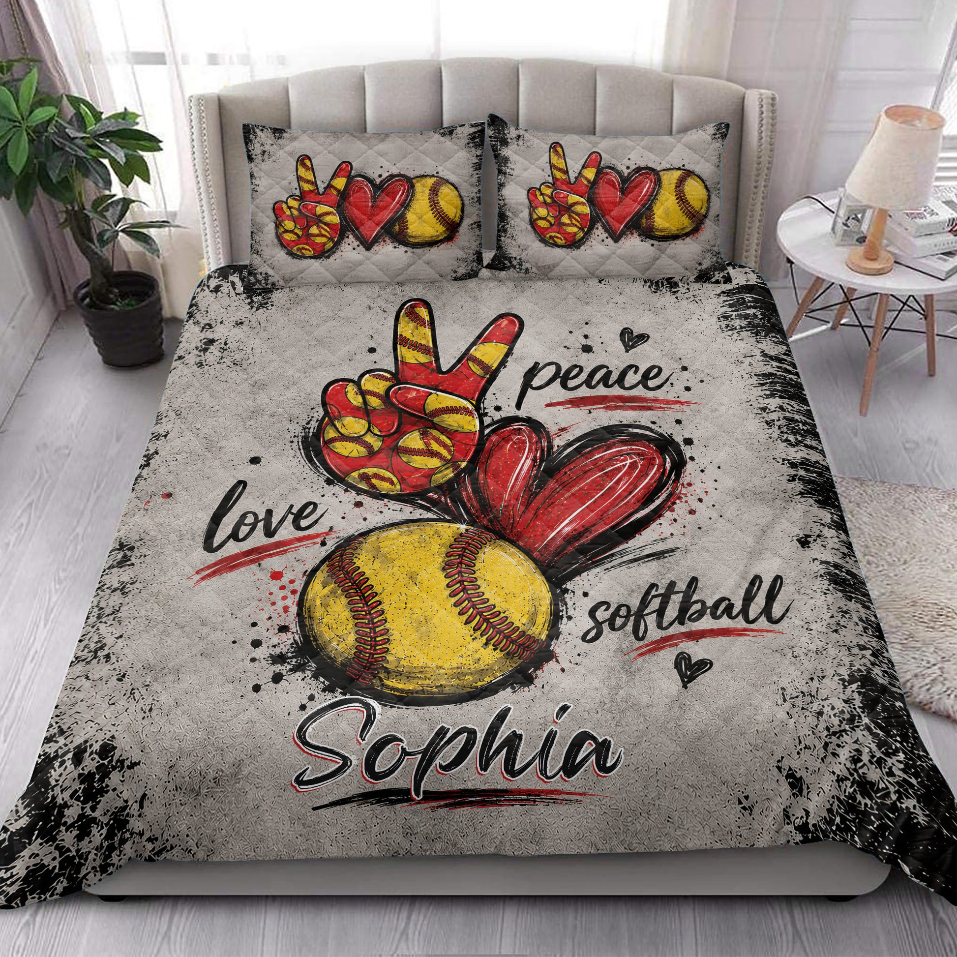 Softball quilt blanket styled in a bright bedroom with red hearts, yellow softballs, and distressed sports artwork