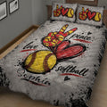 Close bedroom view of a softball quilt blanket featuring a large red heart, yellow softball, and energetic artwork