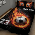 Close bedroom view of a black soccer quilt with a large flaming soccer ball design