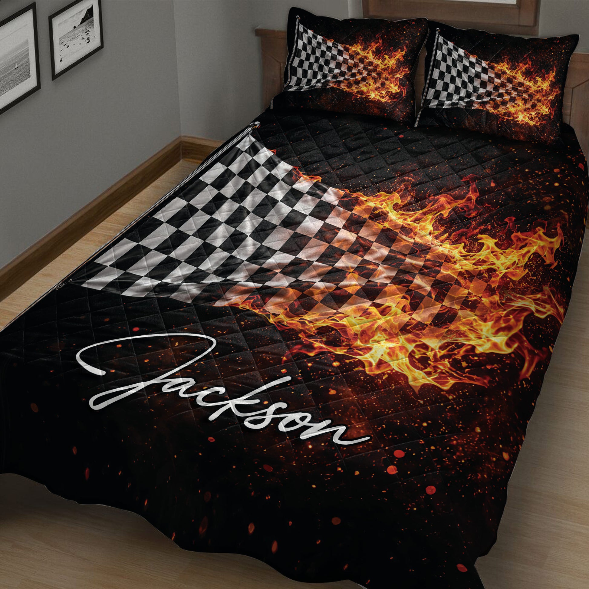 Black racing quilt blanket with fiery checkered flag artwork draped across a bed
