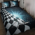 Racing quilt blanket displayed on a bed with black and white checkered flag artwork and blue geometric accents