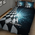 Close bedroom view of a racing quilt blanket featuring black and white checkered flags and deep blue graphics
