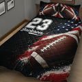 Angled bedroom view of a football quilt blanket with large football artwork and a bold sports-themed design