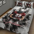 Close bedroom view of a football quilt blanket with dramatic player artwork and red, black, and white colors