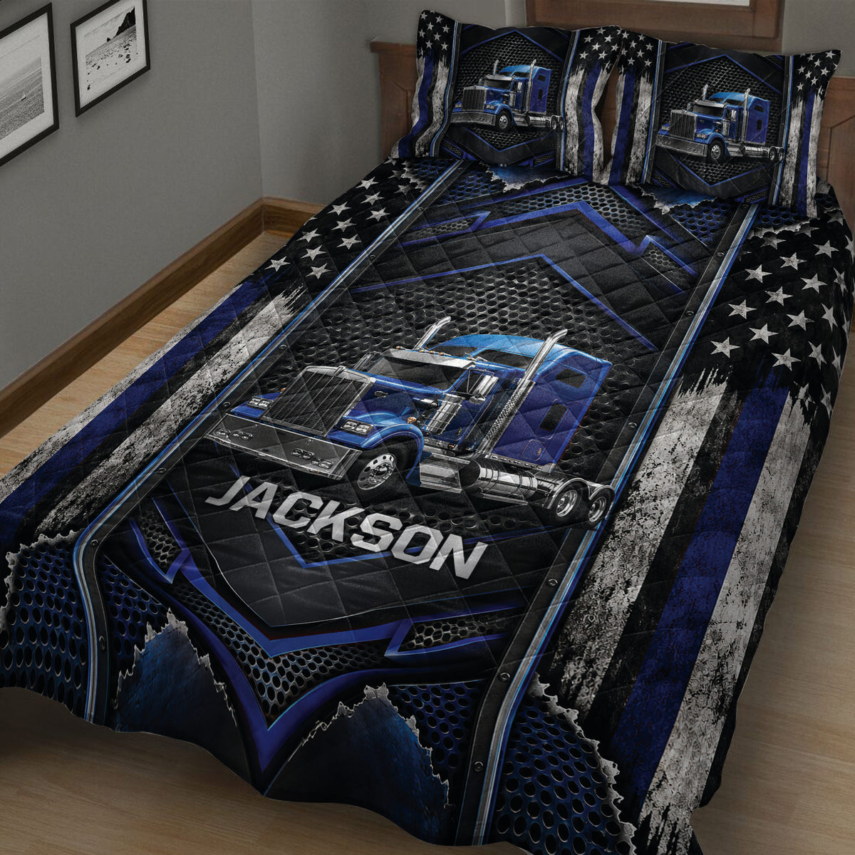 Close-up of a trucker quilt blanket with blue semi-truck artwork, stars, and geometric black accents