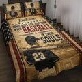 Baseball quilt blanket displayed on a bed with player artwork, stars, bats, and vintage patriotic colors