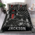 Firefighter quilt bedding styled in a bedroom with helmet artwork, stars, flag stripes, and bold red accents