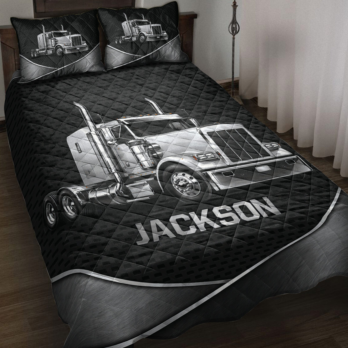 Black trucker quilt blanket set displayed on a bed with silver semi-truck artwork and matching pillow designs