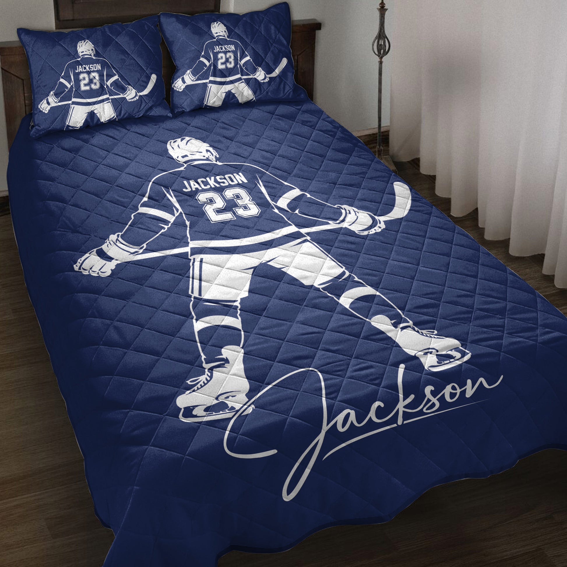 Navy hockey quilt blanket styled on a bed with skater artwork and matching hockey-themed pillow designs