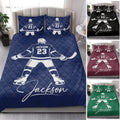 Hockey quilt bedding styled in a bedroom with blue, black, burgundy, and green color examples