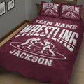 Maroon wrestling quilt blanket displayed on a bed with wrestlers and bold athletic artwork