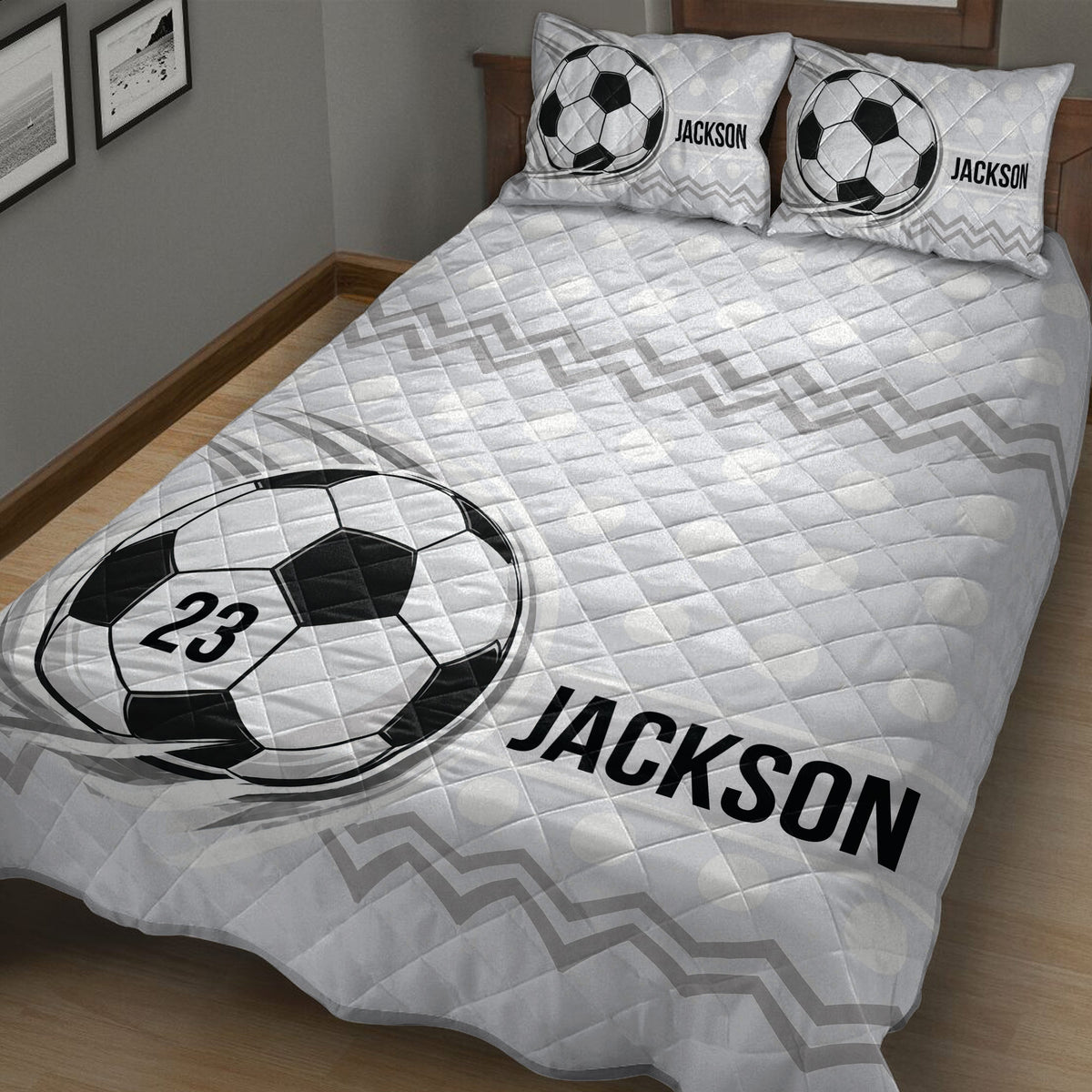 Angled bedroom view of a soccer quilt blanket featuring bold ball artwork and geometric stripes