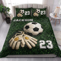 Soccer quilt blanket styled in a bedroom with large soccer ball and goalkeeper glove artwork